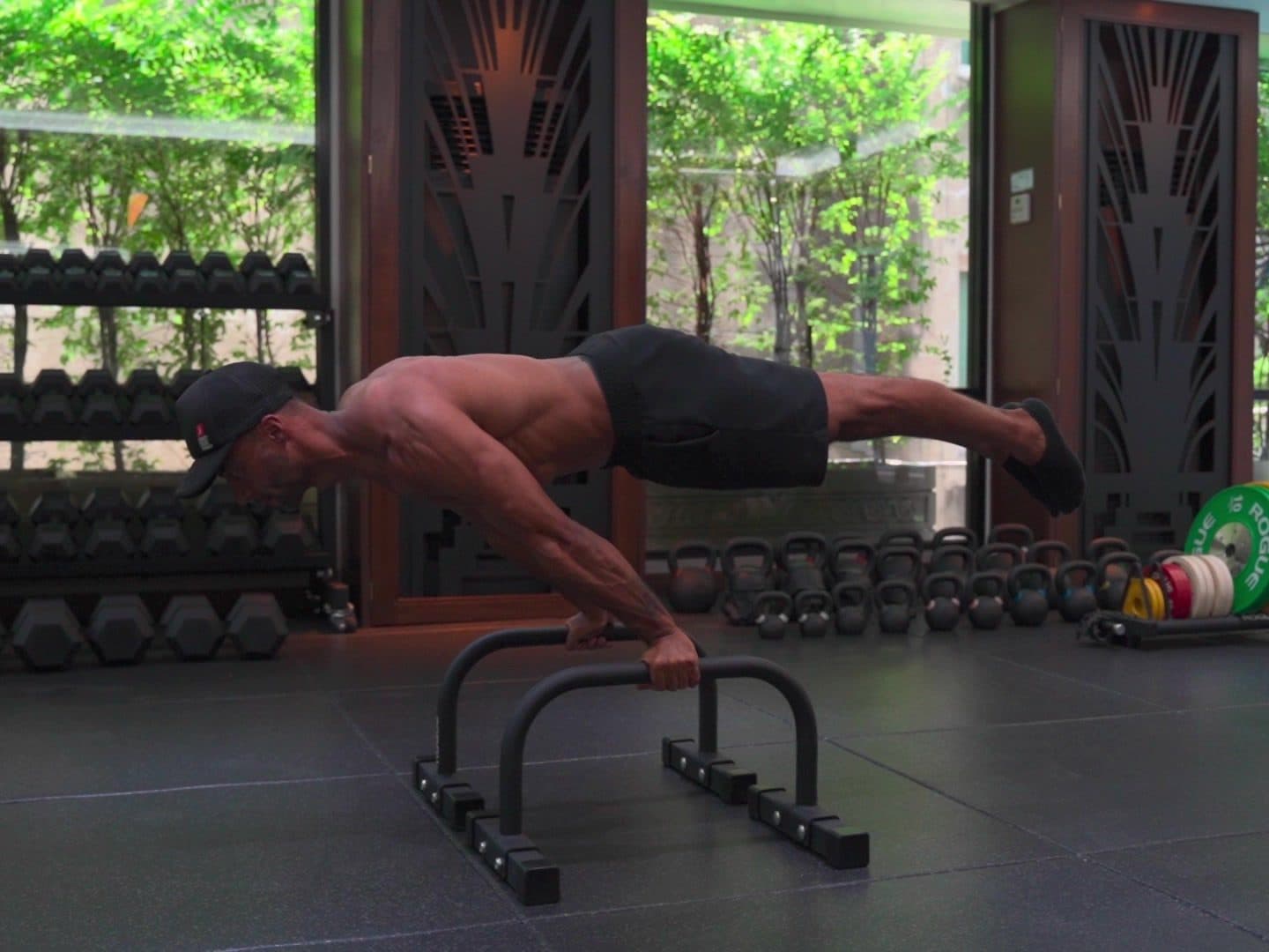 Kemo Marriott holding a planche on parallettes